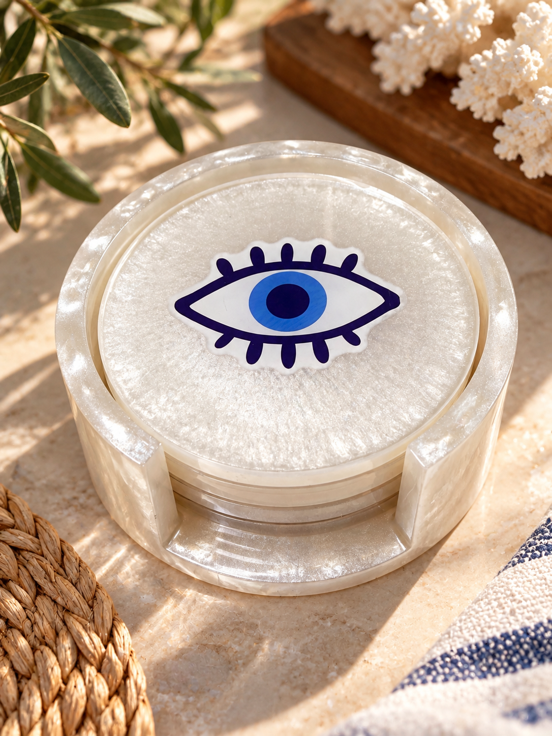 Pearlescent evil eye coasters stacked in their matching holder