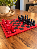 Glossy red and black chessboard with red and black chess pieces