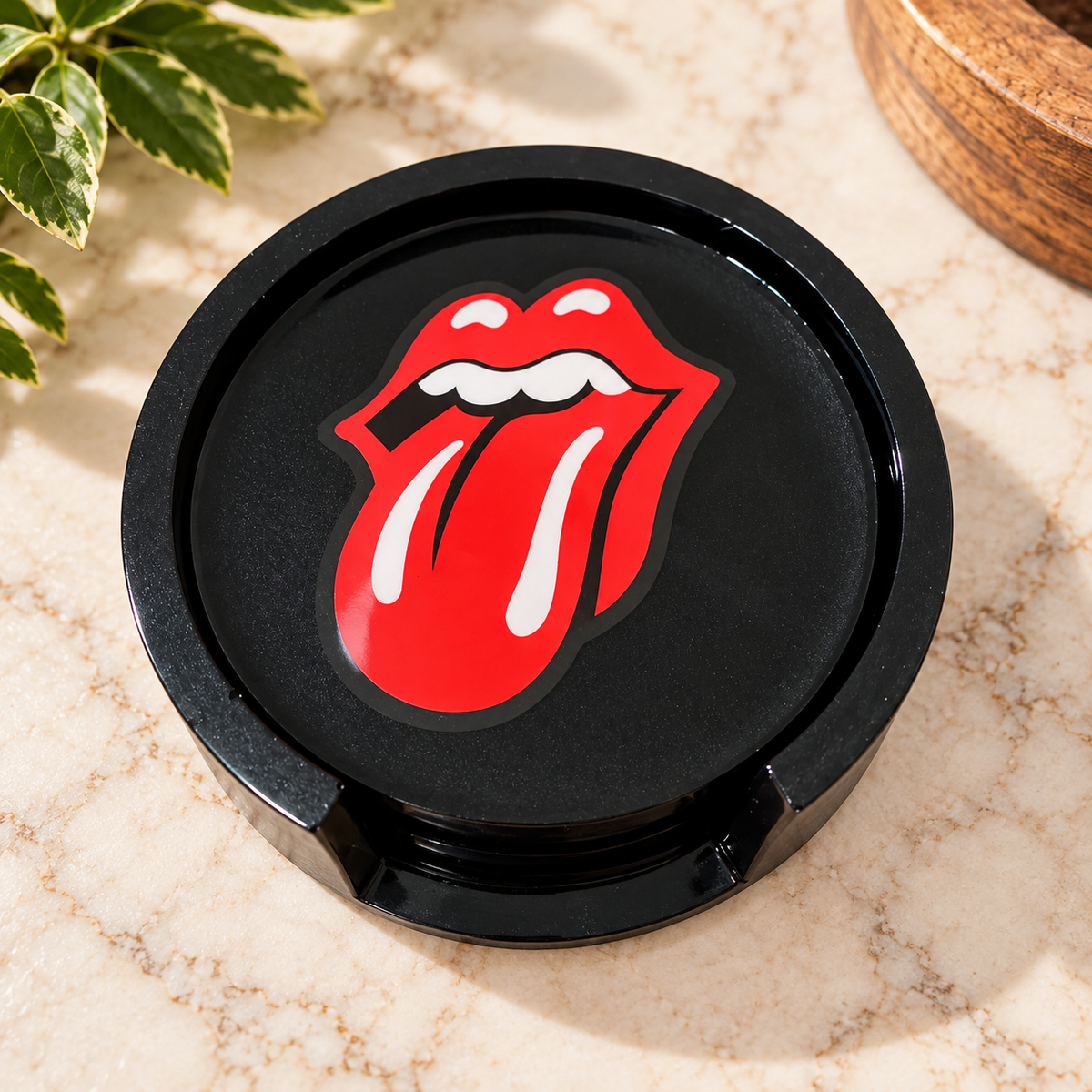 Black Rolling Stones coasters stacked in their matching holder
