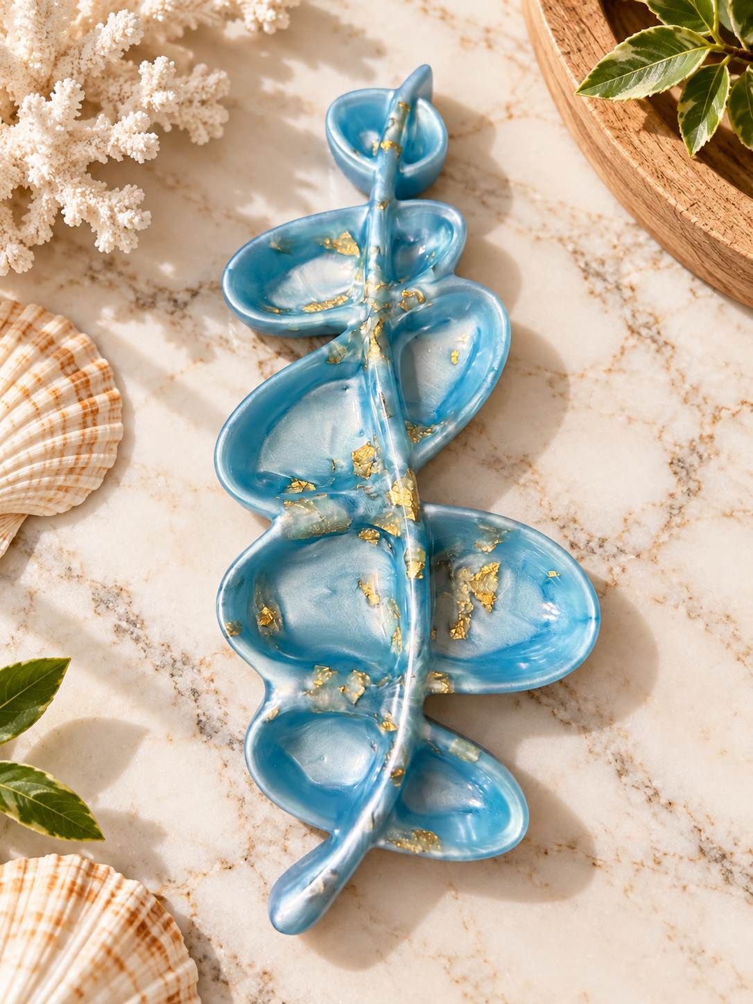 Blue and white leaf-inspired jewelry dish with gold-colored accents and curved compartments