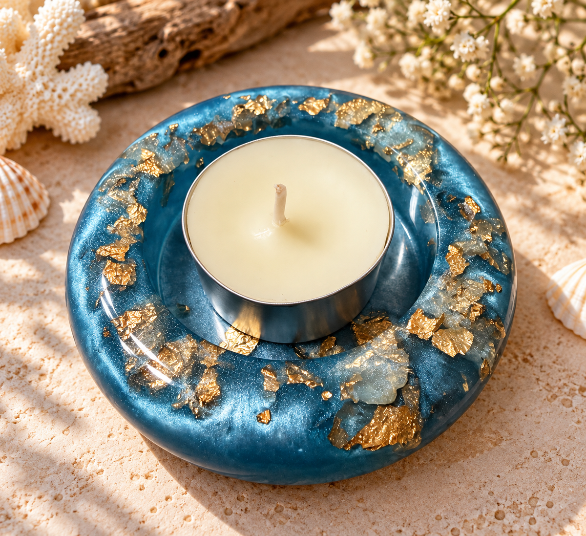 Blue resin candle holder with gold-colored accents and included candle