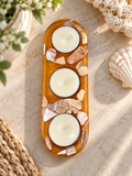 Amber-colored resin holder with shell accents and three included candles