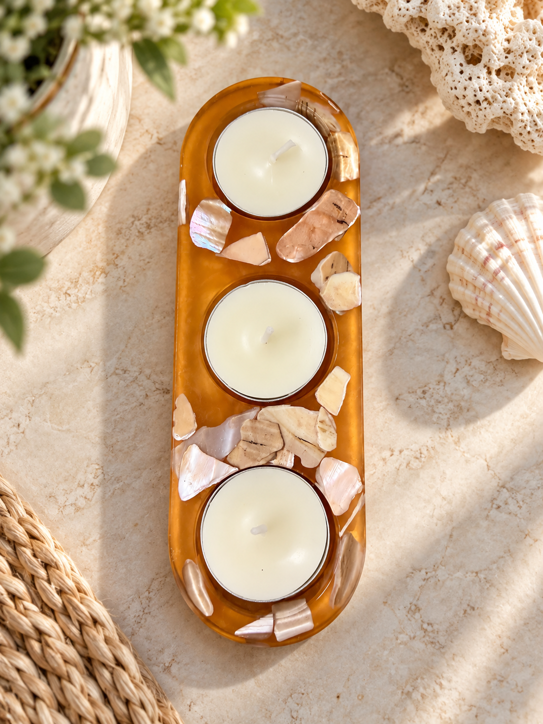 Amber-colored resin holder with shell accents and three included candles